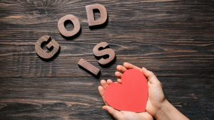 Hands holding a paper heart signifying God is Love