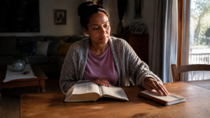 South African woman choosing prayer over bitterness while reading her Bible 
